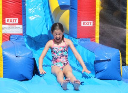 girl coming down inflatable water slide